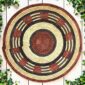 Woven raffia rust, black and natural Burkina platter with a band pattern, on white timber with greenery