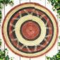 Woven raffia rust, black and natural Burkina platter with a zigzag pattern, on white timber with greenery