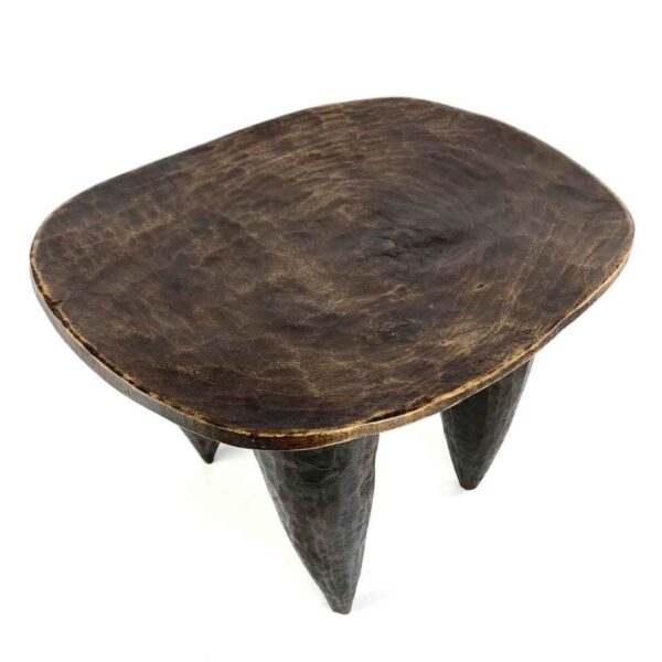 bashiri-senufo-stool-ivorycoast-066-kpatscha-african-stool-wooden-3 Angled view of the carved seat of the dark hardwood Senufo stool with an oval seat and four tapered legs