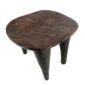 Angled view of the carved seat of the dark hardwood Senufo stool with a rounded square seat