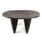 Front view of the low dark hardwood Senufo stool with a wide, elongated seat on a white background