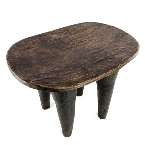 bashiri-senufo-stool-ivorycoast-069-lift-african-stool-wooden-3 Angled view of the carved seat of the tall dark hardwood Senufo stool with four long tapered legs