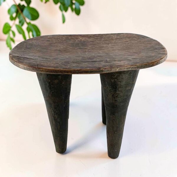 bashiri-senufo-stool-ivorycoast-069-lift-african-stool-wooden-main Tall dark hardwood Senufo stool with four long tapered legs, styled beside a plant