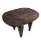 Angled view of the carved seat of the dark hardwood Senufo stool with a broad, dished seat