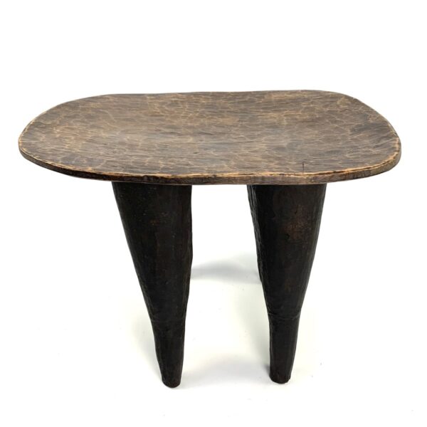 bashiri-senufo-stool-ivorycoast-071-fable-west-african-stool-wooden-2 Front view of the Senufo stool with a lighter worn seat and dark tapered legs on a white background