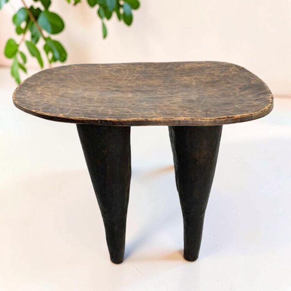 bashiri-senufo-stool-ivorycoast-071-fable-west-african-stool-wooden-main Senufo stool with a lighter worn seat and dark tapered legs, styled beside a plant