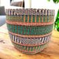 Multicolour woven planter basket with teal, purple and orange stripe pattern on a timber table