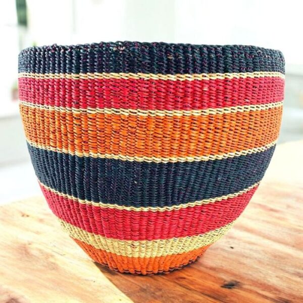 bashiri-woven-planter-basket-red-orange-black-stripe Woven planter basket in bold red, orange and black horizontal stripes on a timber table