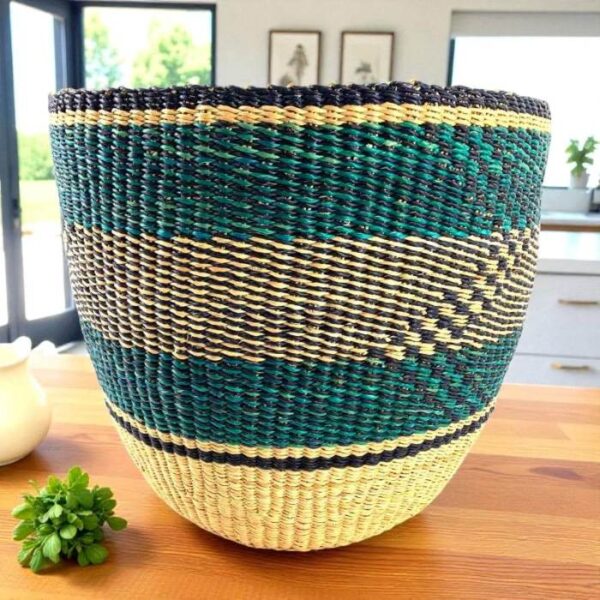 bashiri-woven-planter-basket-teal-black-natural Teal and black woven planter basket with natural straw base on a timber bench