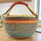 XL round woven Bolga basket in teal, orange and natural elephant grass with leather handle, handcrafted in Bolgatanga Ghana