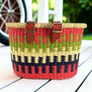 Red Bolga bike basket with green, natural, and navy stepped bands, leather straps and buckles