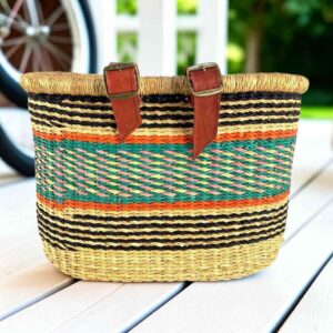 Natural Bolga bike basket with black pinstripes and orange, teal, and pink band, leather straps and buckles