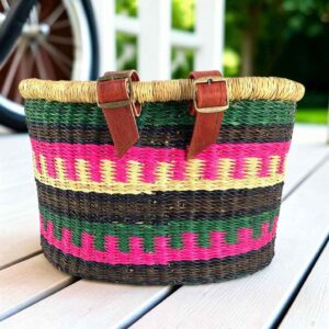 Bolga bike basket in green, black, hot pink, and natural stepped bands, leather straps and buckles