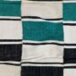 Detail of the checkerboard block pattern with a fringed edge on this handwoven Sahel cotton blanket