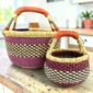 Round Bolga basket duo in pink, green and natural elephant grass with leather handles