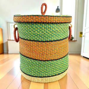 Closed bolga laundry basket, green, orange and black stripes over natural straw, with leather ring handles