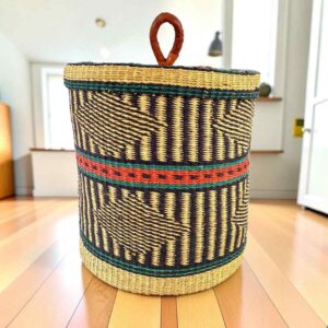 Closed bolga laundry basket, black geometric weave over natural straw with a green and orange band