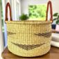 Handwoven African hamper basket in natural elephant grass with dark woven pattern and leather handles, Bolgatanga Ghana