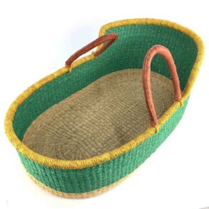 Angled view of the Moses basket with a solid green body, yellow rim, natural base and leather-wrapped handles