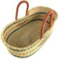 Angled view of the natural Moses basket showing the teal and blue bands inside and the leather handles