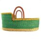 Front view of the green Moses basket with a natural base, yellow rim, and leather handles