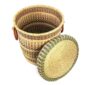 The closed laundry basket with its lid off, showing natural straw with pink, green and black bands, a woven lid and leather ring handles