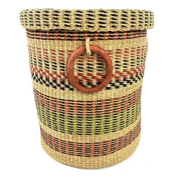 closed-laundry-basket-0304-daal-pink-green-bolga-woven-bashiri-3 Front view of the closed laundry basket with natural straw with pink, green and black bands, a woven lid and leather ring handles on a white background
