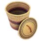 The closed laundry basket with its lid off, showing coral pink and black bands with olive stripes and a woven lid