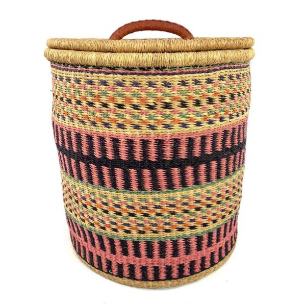 closed-laundry-basket-0305-ember-pink-black-african-bashiri-3 Front view of the closed laundry basket with coral pink and black bands with olive stripes and a woven lid on a white background