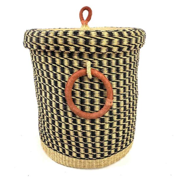 closed-laundry-basket-0307-jones-black-natural-woven-bashiri-3 Front view of the closed laundry basket with a black and natural check, a woven lid and leather ring handles on a white background