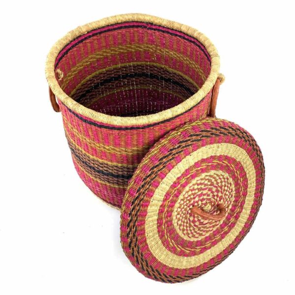 closed-laundry-basket-0308-tinsel-pink-african-bashiri-2 The closed laundry basket with its lid off, showing bright pink with gold and black bands, a patterned woven lid and leather ring handles