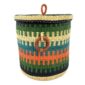 Front view of the closed laundry basket with green, teal and orange stripes, a woven lid and leather ring handles on a white background