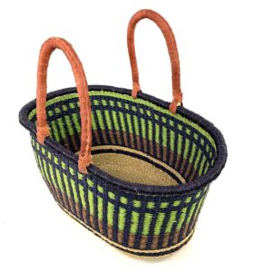Angled view of the extra large oval Bolga basket with lime green vertical stripes over navy, with a navy rim, showing the woven interior