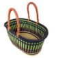 Angled view of the extra large oval Bolga basket with lime green vertical stripes over navy, with a navy rim, showing the woven interior