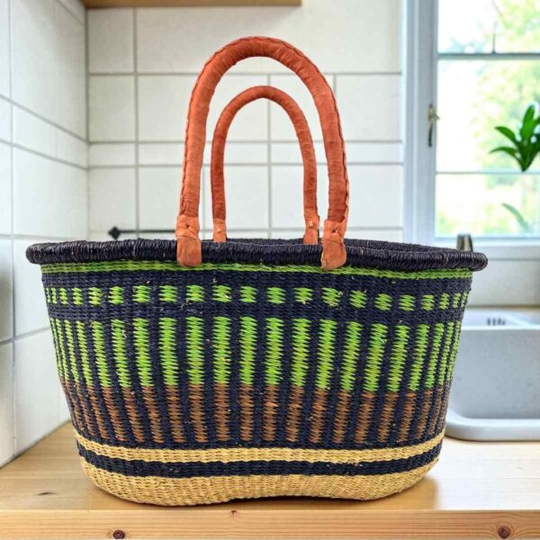 extra-large-oval-011-bamboozle-green-striped-basket-african-bashiri-main Extra large oval Bolga basket with lime green vertical stripes over navy, with a navy rim and leather handles, on a wooden kitchen bench