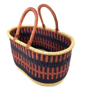 Angled view of the extra large oval Bolga basket with rust orange and navy bands, showing the woven interior
