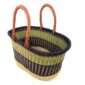 Angled view of the extra large oval Bolga basket with a lime green band between a navy rim and navy lower body, showing the woven interior