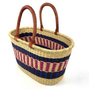 Angled view of the extra large oval Bolga basket with navy bands framing a pink and cream striped band, showing the woven interior