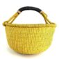 Front view of the yellow XL round Bolga basket with a leather-wrapped handle on a white background