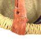Close-up of the scuffed leather handle join on the jewel-toned hamper basket
