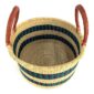 Angled view of the natural hamper basket with dark stripes showing the woven interior