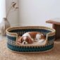 Large teal, navy and natural Bolga pet basket with a small spaniel lying on a cushion inside