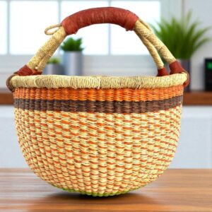 Front view of a medium round Bolga basket, handwoven from elephant grass with a sturdy leather handle