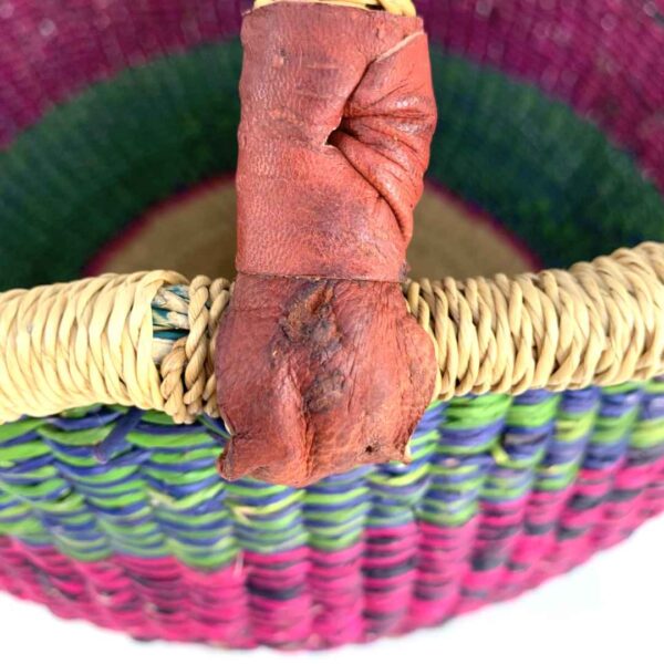 medium-round-basket-665-coastal-woven-4 Close-up of the scuffed leather handle on the medium round Bolga basket, showing the imperfection