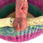 Close-up of the scuffed leather handle on the medium round Bolga basket, showing the imperfection