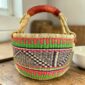 Medium round Bolga basket with coral pink, green and navy zigzag pattern, leather handles