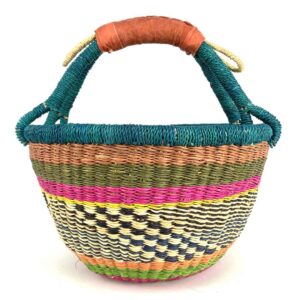 medium-round-basket-667-habitat-woven-2 Angled view of the medium round Bolga basket showing a teal-wrapped rim and handle over terracotta, olive and magenta bands with a black-and-cream diamond weave