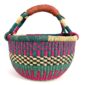 Angled view of the medium round Bolga basket showing a teal and magenta checker weave with a cream-and-black band