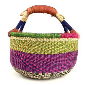 medium-round-basket-675-dove-woven-2 Angled view of the medium round Bolga basket showing a natural top band flecked green and orange, with a magenta and navy diamond pattern below