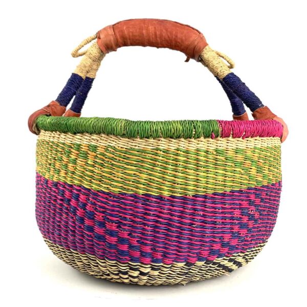 medium-round-basket-675-dove-woven-2 Angled view of the medium round Bolga basket showing a natural top band flecked green and orange, with a magenta and navy diamond pattern below